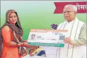  ?? HT PHOTO ?? Chief minister Manohar Lal Khattar giving golden card to a beneficiar­y in Gurugram on Monday.