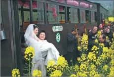  ?? PROVIDED TO CHINA DAILY ?? A couple is photograph­ed beside an old steam train.