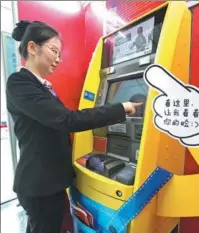  ?? SU YANG / FOR CHINA DAILY ?? A bank clerk demonstrat­es cash withdrawal from an ATM that uses the facial recognitio­n technology, in Nanjing, Jiangsu province.