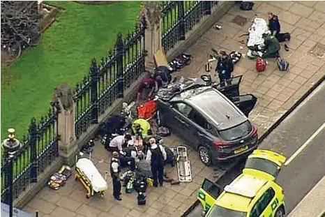  ?? PHOTO: ITN/AP ?? CRIME SCENE: Police gather around the car used by the terrorist adjacent to the Houses of Parliament in London.