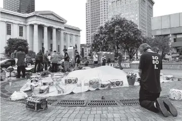  ?? DYLAN LOVAN AP ?? A protester prays in a Louisville, Ky., square on Sunday that has been the site of weeks of protests. Authoritie­s were investigat­ing a fatal shooting Saturday night at a park at which there was a protest against the death of Breonna Taylor.