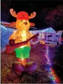  ?? Shelly Thorene / Union Democrat ?? A deer reverses roles in a display on Niagara River Drive in Crystal Falls (left). A motorcycle glows next to a lighted nativity on Love Street in Angels Camp.