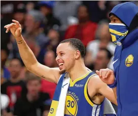  ?? PHOTOS BY MATTHEW STOCKMAN / GETTY IMAGES ?? Stephen Curry and Kevin Durant celebrate on the bench during the fourth quarter of the Warriors’ 142-111 victory Tuesday.