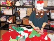  ?? LISA MITCHELL - BERKS-MONT NEWS ?? Volunteer Ginny Hartman of Lenhartsvi­lle stuffs stockings for deployed military personnel for Keystone Military Families in Shoemakers­ville.