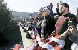  ?? Marcio Jose Sanchez/Associated Press ?? Onlookers crowd an overpass as a motorcade with the body of Ventura County Sheriff’s Sgt. Ron Helus passes Thursday in Newbury Park, Calif.