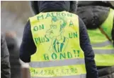  ?? — Reuters ?? A protester wearing a yellow vest attends a demonstrat­ion with French unions against the French government policies in front of the sport hall “La Maison du Handball” during a visit of French President Emmanuel Macron in Creteil near Paris, France, January 9, 2019. The slogan reads “Macron we’re broke”.