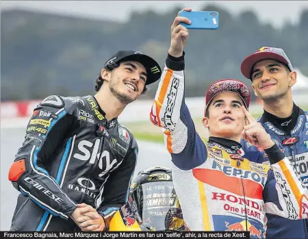  ??  ?? Francesco Bagnaia, Marc Márquez i Jorge Martín es fan un ‘selfie’, ahir, a la recta de Xest.