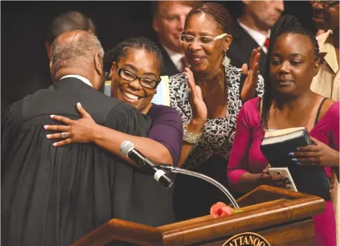  ?? STAFF PHOTO BY ANGELA LEWIS FOSTER ?? Judge Curtis L. Collier, left, hugs Demetrus Coonrod after administer­ing the oath of office April 17 at the Tivoli Theatre in Chattanoog­a.