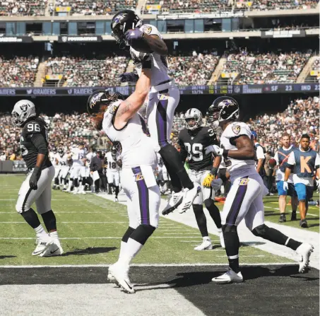  ?? Carlos Avila Gonzalez / The Chronicle ?? Center Ryan Jensen hoists Vince Mayle after his touchdown put the Ravens up 2:15 into the game, giving them the lead for good.