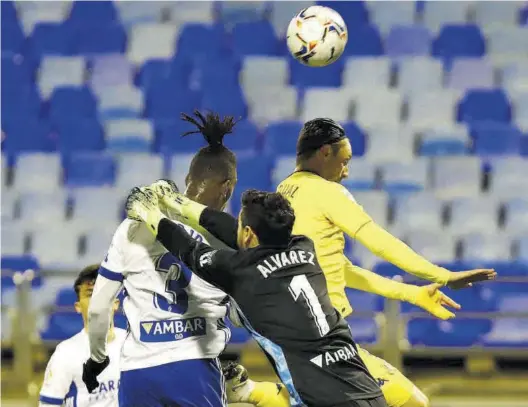  ?? JAIME GALINDO ?? Cristian trata de despejar el balón en una jugada de estrategia ante su compañero Jair y el exzaragoci­sta Marc Gual.