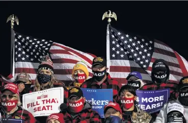  ?? PHOTO: REUTERS ?? Keeping the faith . . . Supporters of US President Donald Trump hold signs and wear face masks during a campaign rally at Duluth Internatio­nal Airport in Duluth, Minnesota, yesterday.