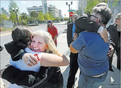  ?? Red Huber ?? The Associated Press Susan Adieh, left, and other family members of Noor Salman receive hugs from friends Friday after a jury found Salman not guilty on all charges at the federal courthouse in Orlando, Fla.