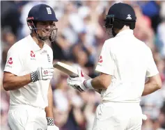  ?? — AFP photo ?? Alastair Cook (left) celebrates with Joe Root after reaching 50 runs on the fourth day of the fifth Test cricket match between England and India at The Oval in London.
