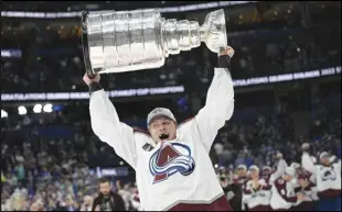  ?? Associated Press ?? Colorado Avalanche defenseman Erik Johnson lifts the Stanley Cup after the team defeated the Tampa Bay Lightning in Game 6 of the NHL hockey Stanley Cup Finals on Sunday in Tampa, Fla.