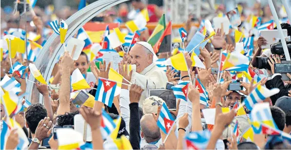  ??  ?? Joyful crowds waved a host of Cuban and Vatican flags to greet Pope Francis as he arrived for a Mass in Revolution Square in Havana yesterday at the start of an eight-day visit to Cuba and the United States