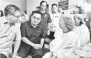 ??  ?? PROGRAM CSR: Jiwari (duduk, dua kiri) bersama Nyabong (duduk, kiri) berbual dengan pesakit yang menjalani pembedahan sambil diperhatik­an Jamit (berdiri, kiri) serta yang lain.