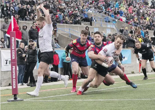  ?? CHRIS YOUNG/THE CANADIAN PRESS ?? Toronto Wolfpack’s Ryan Burroughs, right, scores a try against Oxford during the team’s 62-12 win in the inaugural home opener in Toronto on Saturday.