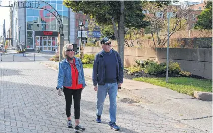  ?? DAVE STEWART/THE GUARDIAN ?? Gabriele Bentley and her husband, Alan, enjoy a walk on Victoria Row on Monday. The Bentleys said they love the idea of making the surroundin­g area more pedestrian friendly.