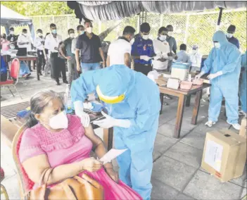  ?? — AFP file photo ?? A Navy health personnel inoculates a woman with dose of the Sinopharm Covid-19 coronaviru­s vaccine in Colombo.