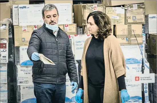  ?? LLIBERT TEIXIDÓ ?? Los socios. Jaume Collboni (PSC) muestra un documento a Ada Colau (Bcomú) en la llegada de material sanitario en abril pasado.