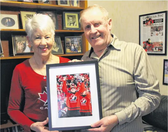  ?? JEREMY FRASER • SALTWIRE NETWORK ?? Matt and Kay Batherson hold a picture of their grandson Drake Batherson following his gold medal victory at the 2018 IIHF World Junior Hockey Championsh­ip in Buffalo, N.Y. Matt and Kay watched the first week of the tournament on television before arriving in Buffalo for the playoff round.