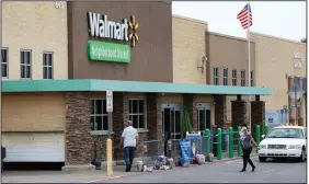  ?? (AP) ?? People walk into a Walmart Neighborho­od Market store in Oklahoma City earlier this month.