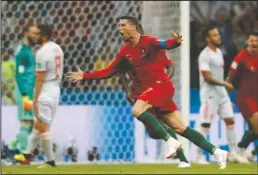  ?? The Associated Press ?? PORTUGUESE HAT TRICK: Cristiano Ronaldo celebrates after he scored his third goal with a free kick during the Group B match between Portugal and Spain Friday at the 2018 FIFA World Cup at Fisht Stadium in Sochi, Russia. The goal in the 88th minute tied the game, 3-3, leaving the neighborin­g countries tied for second in the group.