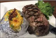  ?? Arkansas Democrat-Gazette/ERIC E. HARRISON ?? Camp David serves its 12-ounce rib-eye with a loaded baked potato.