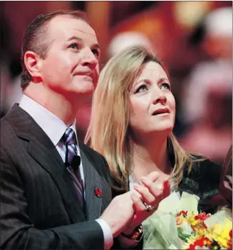  ?? Ted Rhodes, Calgary Herald ?? Former Flame Al Macinnis — a Hockey Hall of Fame D-man — and his wife Jackie watch as his Forever A Flame banner is raised to the Saddledome rafters before Monday’s game against the St. Louis Blues.