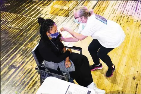  ?? ?? In this Aug. 8, 2021, file photo, a patient receives a Pfizer vaccine shot at a pop-up COVID-19 vaccinatio­n center, set up at Heaven night club in London. Britain’s Conservati­ve government is hoping a combinatio­n of relatively high vaccinatio­n rates and common-sense behavior will keep a lid on coronaviru­s infections this fall and winter and avoid the need for restrictiv­e measures. That plan employs a lighter touch than most nations. (AP)