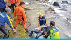  ??  ?? PAGAR ALAM: Indonesia’s national search and rescue agency (BASARNAS) rescue personnel retrieving a victim after a bus careered into a 150-metre deep ravine and ended up in a river killing dozens, near Perahu Dipo village in Pagar Alam, South Sumatra. — AFP