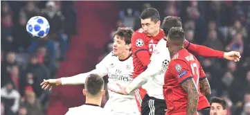  ?? — AFP photo ?? Bayern Munich’s Polish forward Robert Lewandowsk­i (centre) heads in the 4-1 goal during the UEFA Champions League Group E football match Bayern Munich vs Benfica Lisbon in Munich, southern Germany.