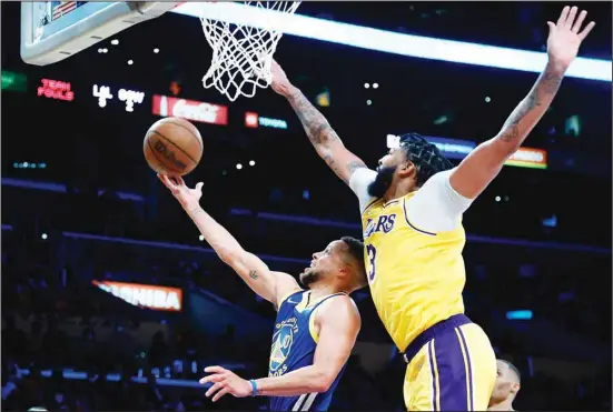  ?? ?? Golden State Warriors guard Stephen Curry shoots as Los Angeles Lakers forward Anthony Davis defends during the second half of an NBA basketball game in Los Angeles, on Oct. 19. (AP)