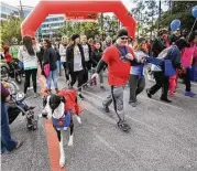  ?? Michael Minasi ?? Decked out in team T-shirts or costumes, participan­ts in the American Heart Associatio­n’s Heart Walk take off from the starting line on Saturday at Alight Solutions in The Woodlands.