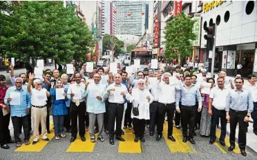  ??  ?? Unfair move: Disgruntle­d Barra members standing on a pedestrian walkway in Jalan Tuanku Abdul Rahman to protest against the closing of the road to traffic.