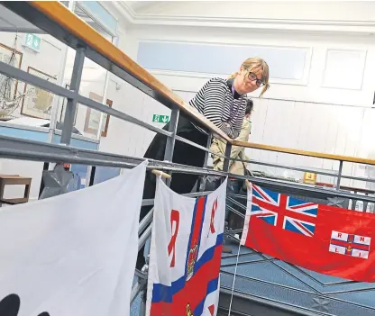  ??  ?? Museum officer Caroline Taylor with some of the flags on show.