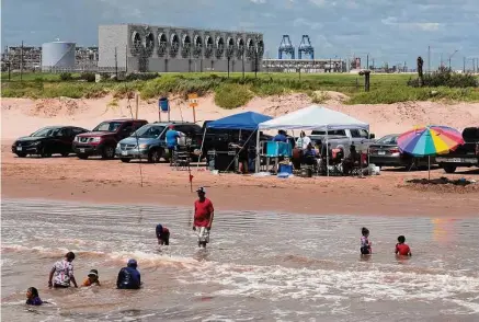  ?? Photos by Marie D. De Jesús/Staff photograph­er ?? People spend the afternoon fishing and swimming at Quintana Beach, where a liquefied natural gas plant looms.