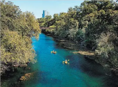  ?? AUSTIN CONVENTION & VISITORS BUREAU ?? Kayakers paddle in Austin’s Lady Bird Lake, where there’s also a trail that’s popular for land-based fitness pursuits.