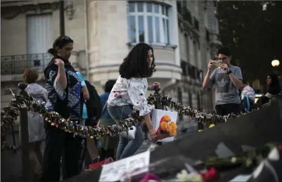  ?? KAMIL ZIHNIOGLU, THE ASSOCIATED PRESS ?? A woman places roses to pay tribute to the late Princess Diana above the Pont de l’Alma tunnel in Paris on Thursday.