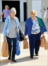  ?? Janelle Jessen/Herald-Leader ?? Rosemary Hanes, of Claremore, Okla., and Mary Gibson of Adair, Okla., carried their bags to their cars after shopping at DaySpring’s annual Outlet Sale on Friday morning.