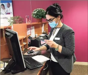  ?? Luther Turmelle / Hearst Connecticu­t Media ?? Mina Ghazi, a branch operations supervisor, looks up a transactio­n for a customer at the College Street Liberty Bank location in New Haven.