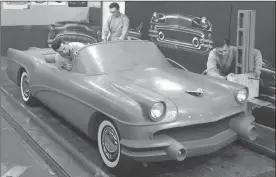  ?? Courtesy of General Motors via AP ?? This 1954 photo Courtesy of General Motors shows Buick Design Studio creative clay sculptors as they mold the clay on a model GM automobile.