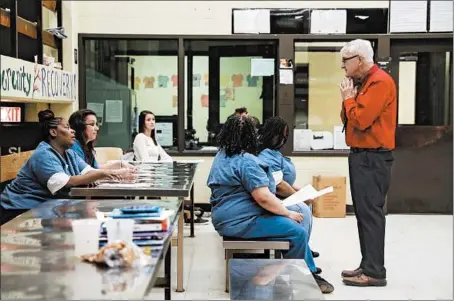  ?? JOSE M. OSORIO/CHICAGO TRIBUNE ?? Mike McGillicud­dy, a retired social worker who runs a Kolbe House program, speaks to detainees at Cook County Jail in Chicago in November.