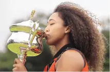  ?? HAMISH BLAIR/ASSOCIATED PRESS ?? Naomi Osaka kisses the Daphne Akhurst Memorial Cup the day after defeating Jennifer Brady in the women’s singles final at the Australian Open.