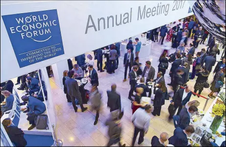  ?? EPA ?? Participan­ts stand in the lobby of the congress center during the closing day of the 47th annual meeting of the World Economic Forum in Davos, Switzerlan­d.