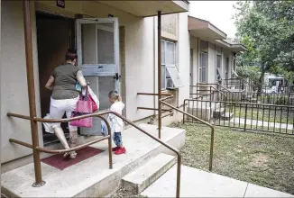  ?? PHOTOS BY RICARDO B. BRAZZIELL / AMERICAN-STATESMAN ?? Savannah Annas walks to her home with her children Thursday in East Austin in one of the city’s affordable housing communitie­s. Affordable housing remains an issue in Travis County, where 36 percent of households are “cost-burdened,” according to a new...