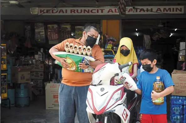  ?? ?? File photo of a family buying foodstuff from a kedai runcit in Gombak, selangor. The government’s decision to provide financial assistance was made after taking into considerat­ion rising living costs and food prices. – azhar mahfof/the star