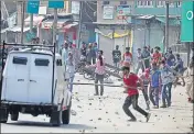  ?? WASEEM ANDRABI /HT ?? Protesters clash with security forces and throw stones at an army vehicle after the funeral of militant Yawar Nissar in Kashmir’s Anantnag district on Friday.