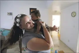  ?? DARRON CUMMINGS — THE ASSOCIATED PRESS ?? Shawnee Wilson holds her son, Kingston, in her apartment in Indianapol­is. Despite some relapses, she’s been clean for several months and is convinced she’ll be able to keep it up.