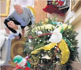  ?? GARY W. GREEN/STAFF PHOTOGRAPH­ER ?? Fritz Rapp, 85, and daughter Kayla Mudge, 30, decorate their home Thursday in Orlando’s Baldwin Park. They plan to have at least 6 Christmas trees this year.